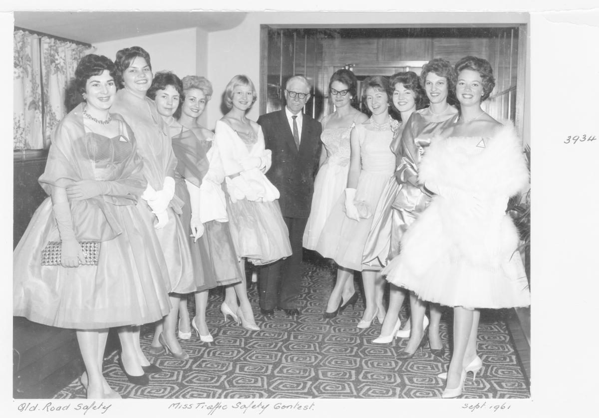 Miss Traffic Safety Quest 1961 contestants in evening dress, with judge - Brisbane, September 1961