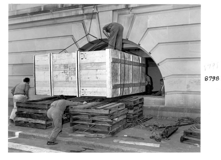 Camera rear section being unloaded and directed through the window opening, William Street, Brisbane, April 1970