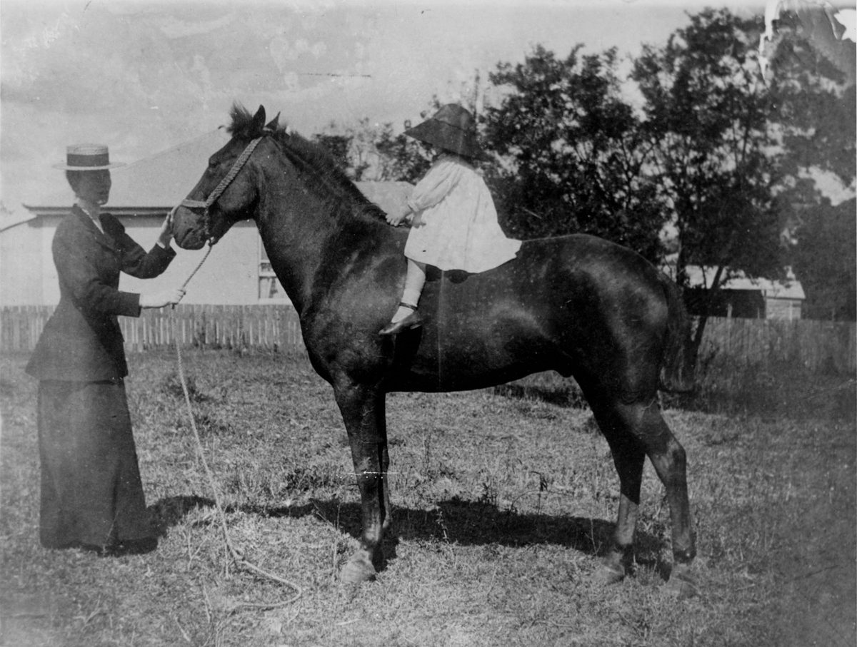 Mrs. Elsie Stuart supervising her daughter, Wanda, on 'Bubbles' the horse, 1899