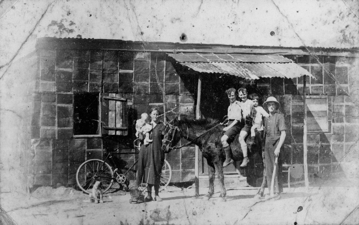 Family in front of house made of kerosene tins at Wakerley, Brisbane, 1927