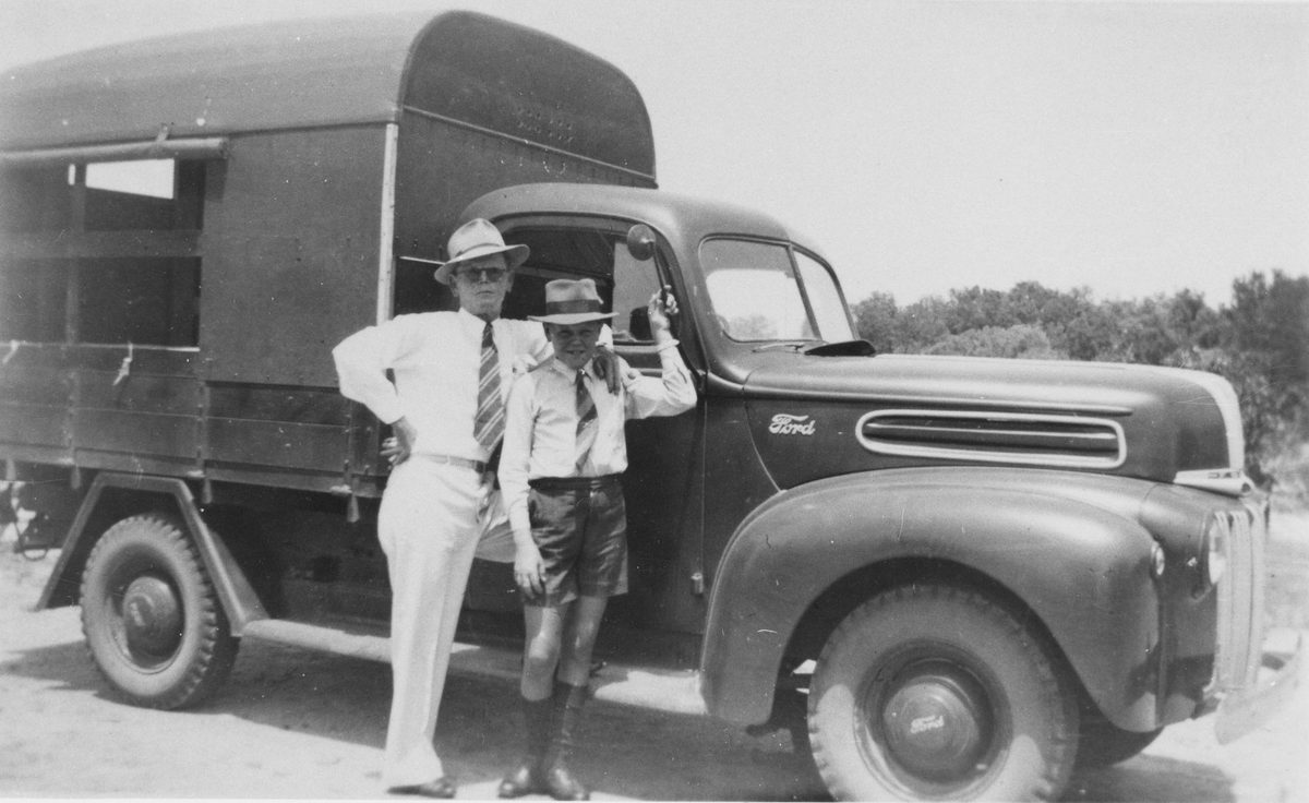 Two leprosy patients pose in front of a truck provided for the transportation of patients across Peel Island, 1945