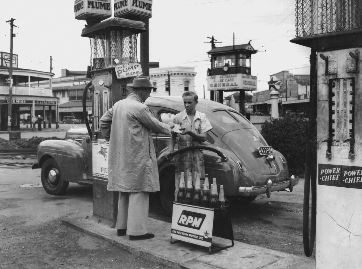 Filling the car with petrol at the Fiveways, Woolloongabba, 1949