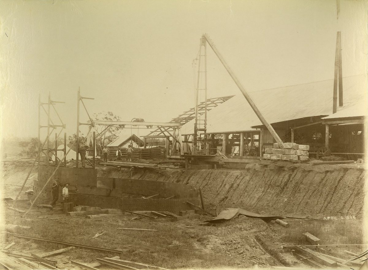 Riveting the large steel bridge supports on the bank, April 1894