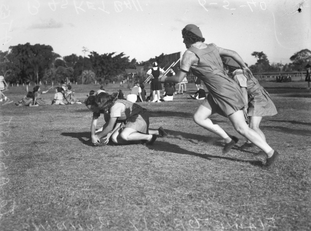 Girls wrestling over the ball during a netball game in Brisbane, 1940