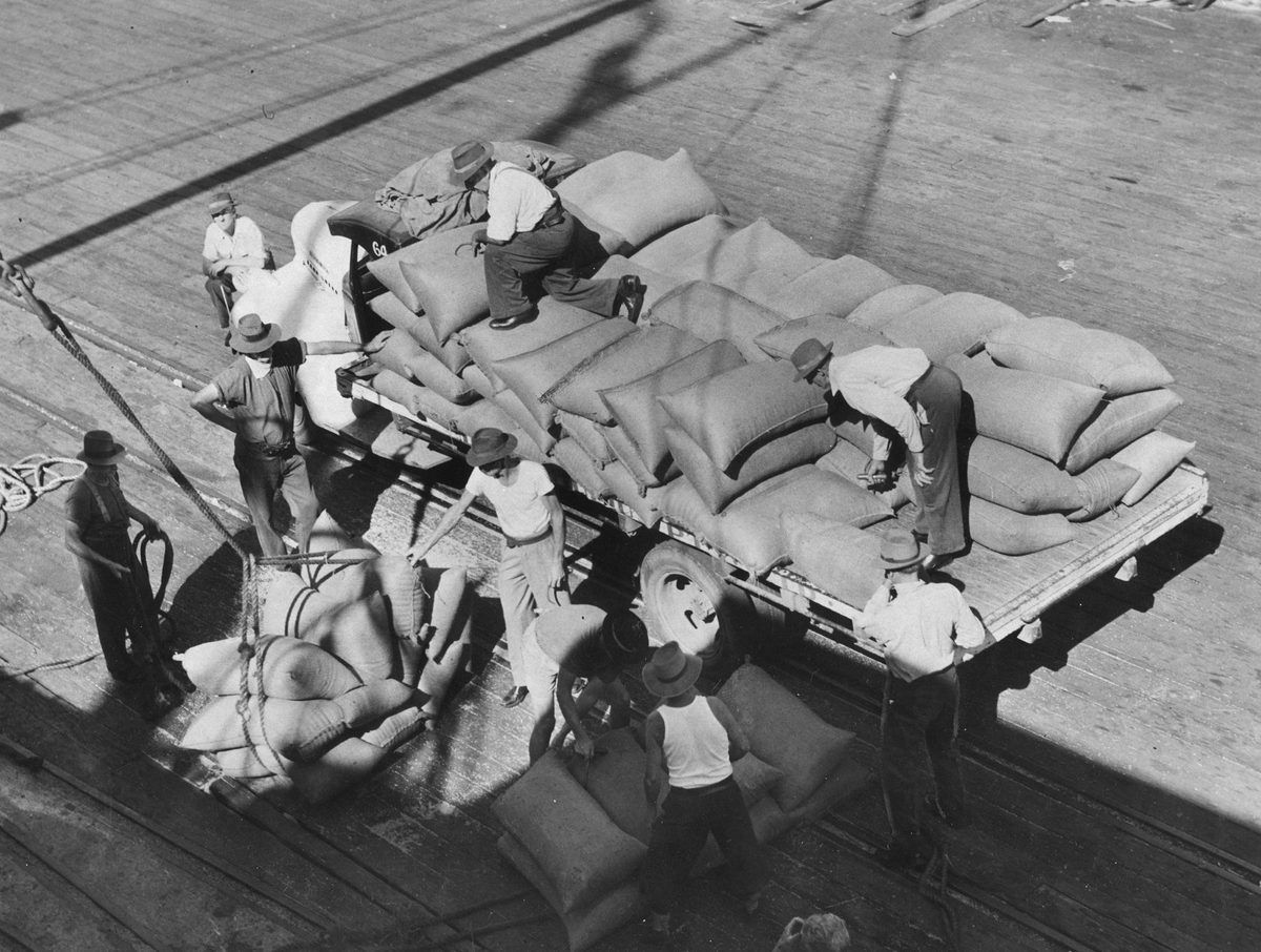 Bags of wheat being loaded into the Indian Government freighter Bombay at Mercantile Wharf, Brisbane, 1953