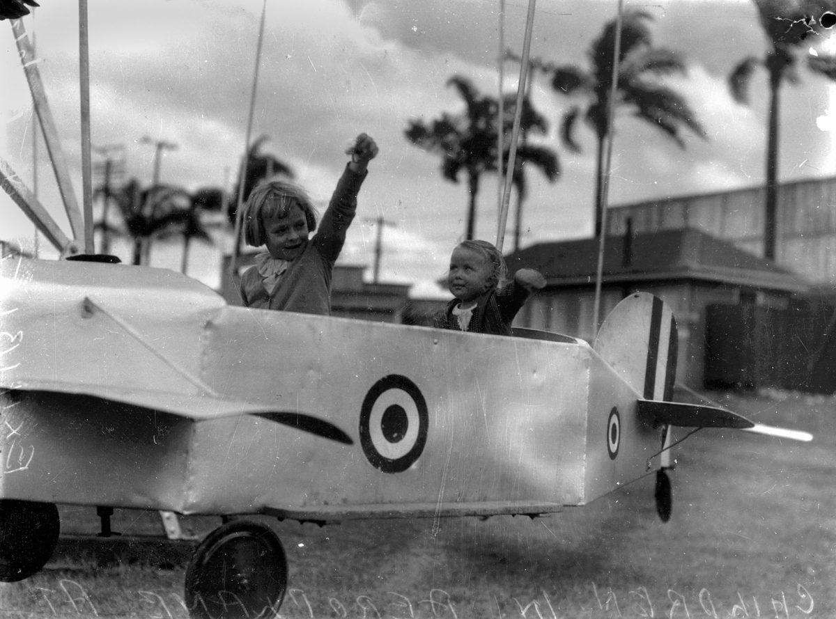 Children enjoying an aeroplane ride at the Exhibition, Brisbane, 1938
