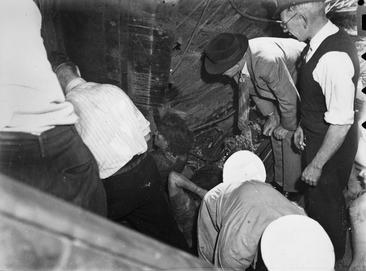 Rescue workers attempt to free injured passengers from a train wreckage at Camp Mountain, 1947
