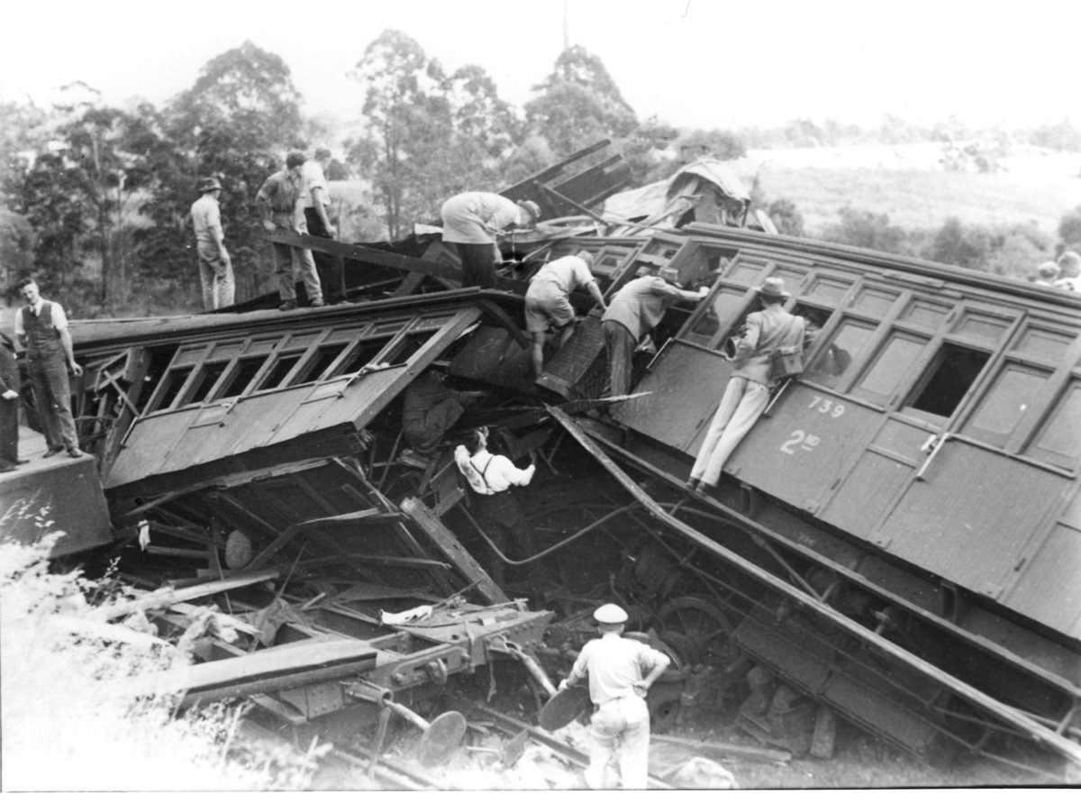 Relief workers inspect smashed carriages after railway accident at Camp Mountain, Queensland, 1947