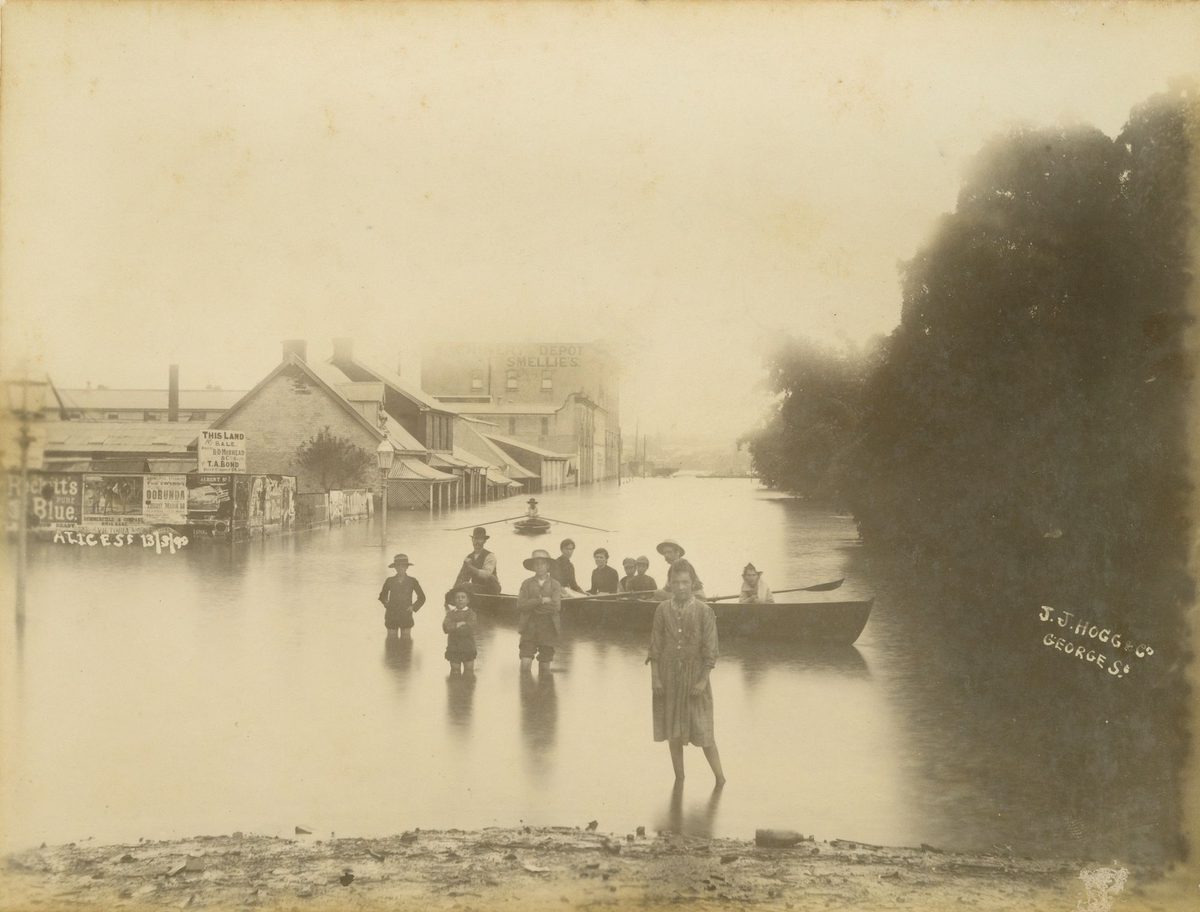 Children gathered around a boat floating in floodwaters in Alice Street, Brisbane, 1890