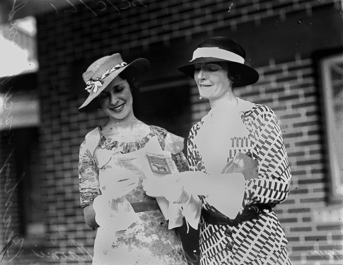 Miss G. Griffin and Miss N. Beasley studying the form guide at the Brisbane races, 1934