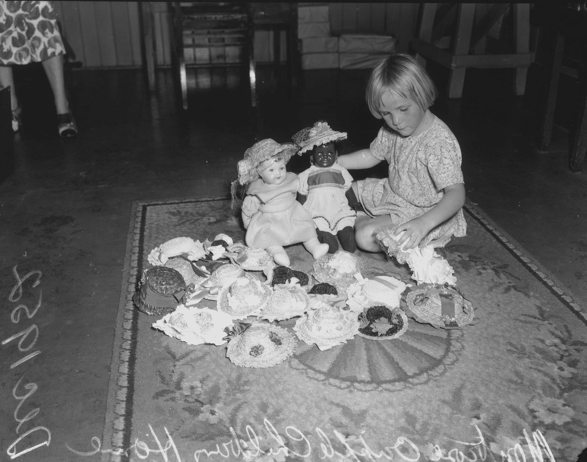 Young girl with a disability, playing with her dolls, 1952