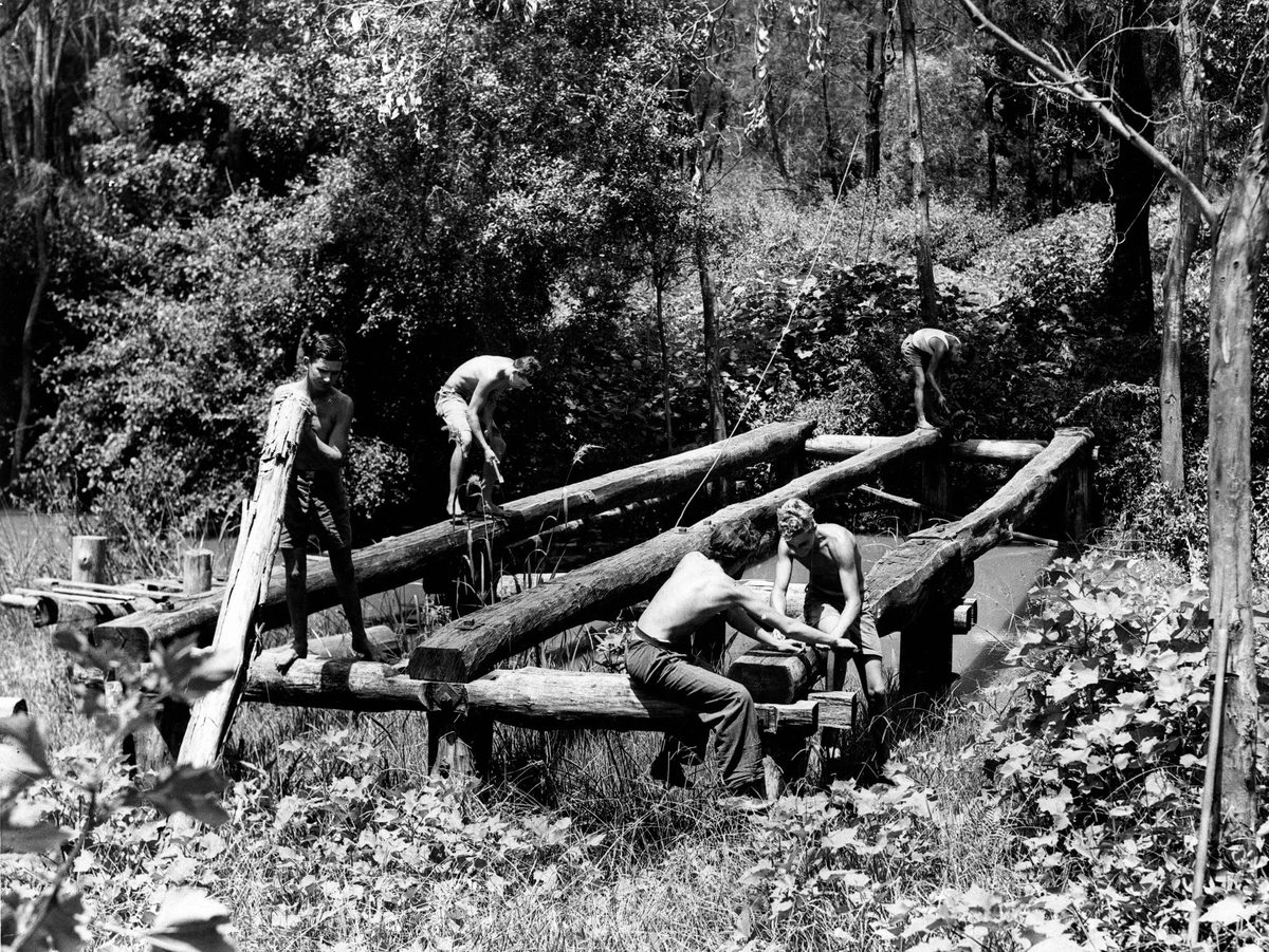 Students from the St. Lucia Farm School constructing a bridge over a creek at Moggill, Brisbane, 1937