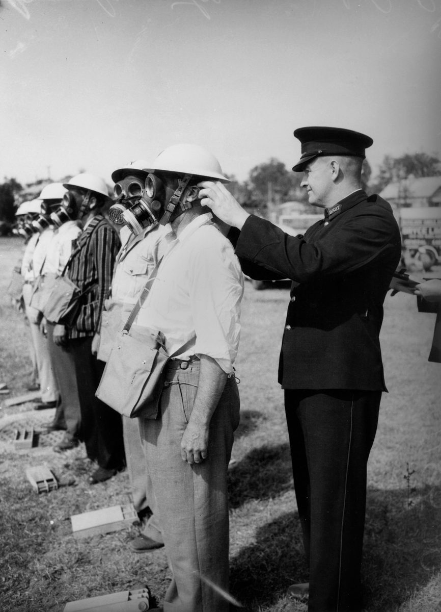 Men in gasmasks lined up for inspection, Rosalie-Torwood, September 1942