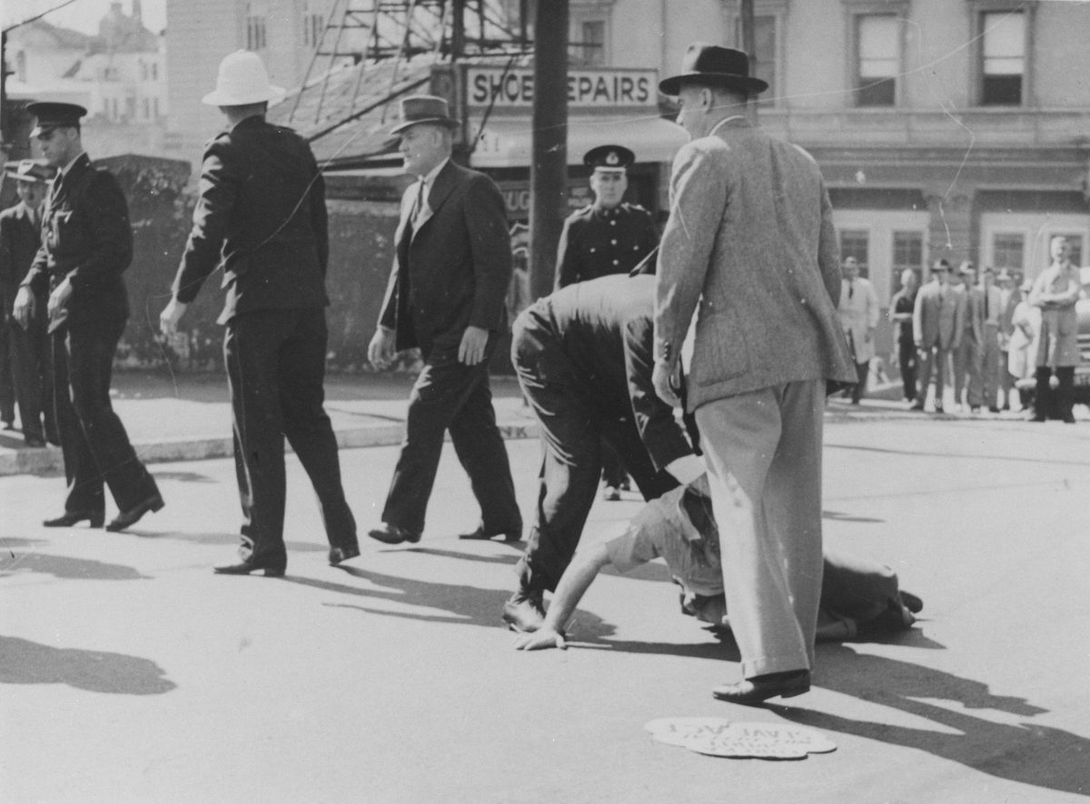 Injuired man lying on the ground during the Railway workers' strike, St Patrick's Day, Edward Street, Brisbane