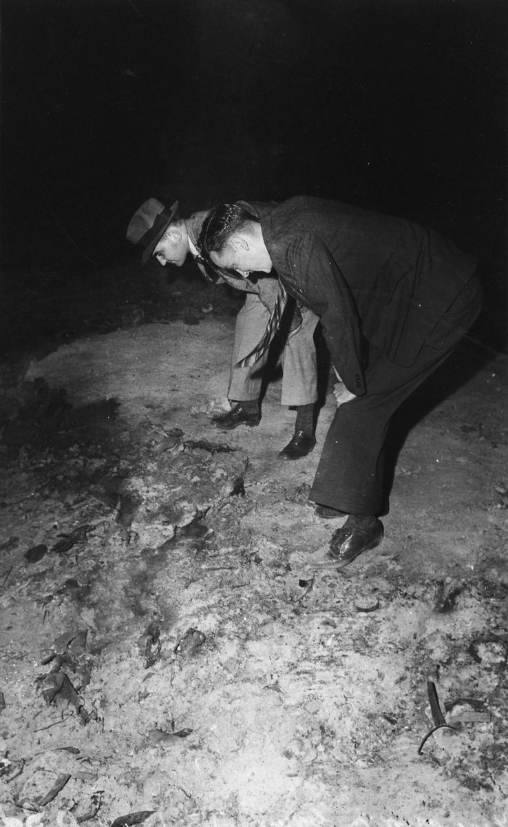 Two men investigate the site of the fire which destroyed the business premises of R.M. Gow & Co. Pty. Ltd. in Turbot Street, Brisbane, 1942