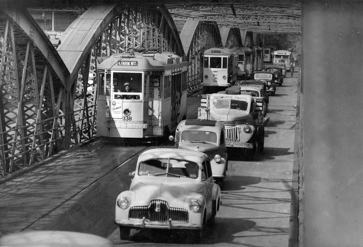 Cars and trams travelling along Victoria Bridge, Brisbane, 1952