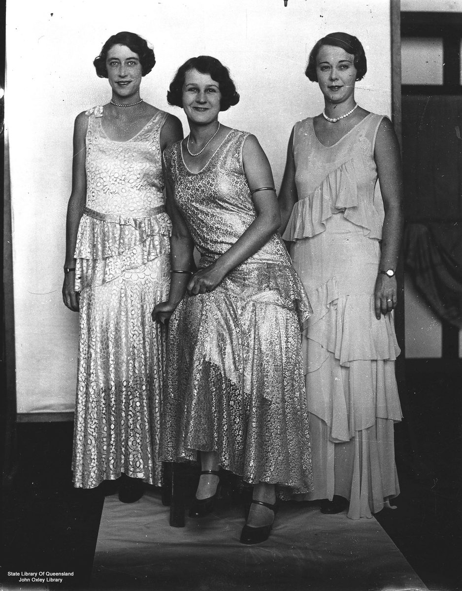 Three women in evening gowns at a fashion parade in 1931