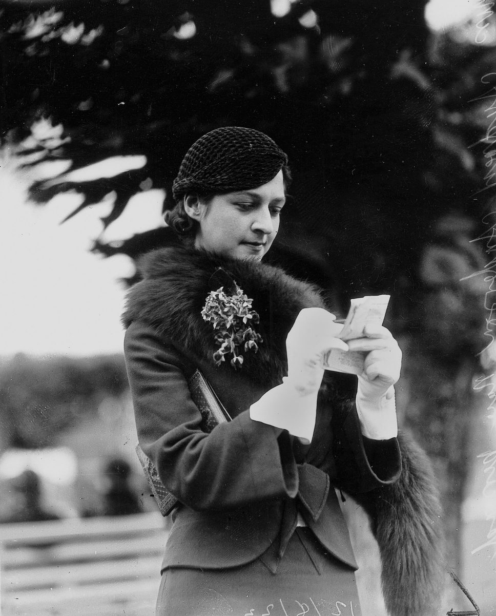 Queensland pianist, Audrey Anderson, studies the form guide at Ascot races, Brisbane, August 1933