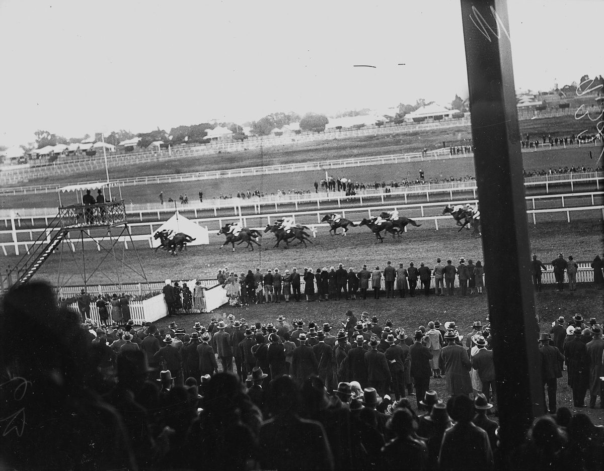 Crowds watch the finish of the Ascot Handicap at Eagle Farm races, Brisbane, August 1932