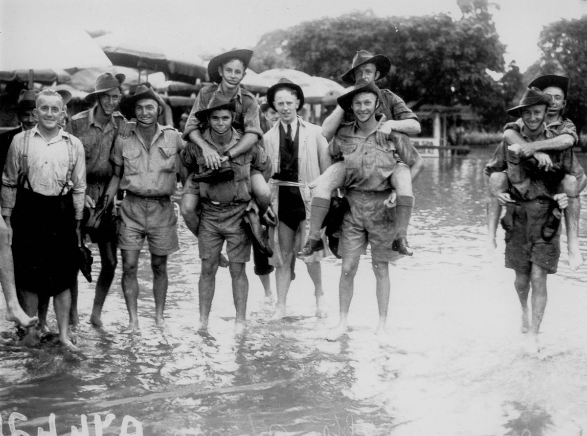Soldiers enjoying a day at the races, despite the storm at Albion Park, Brisbane, January 1941