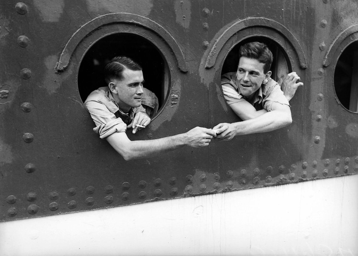 Soldiers looking out the portholes of a ship returning home from overseas, 1942
