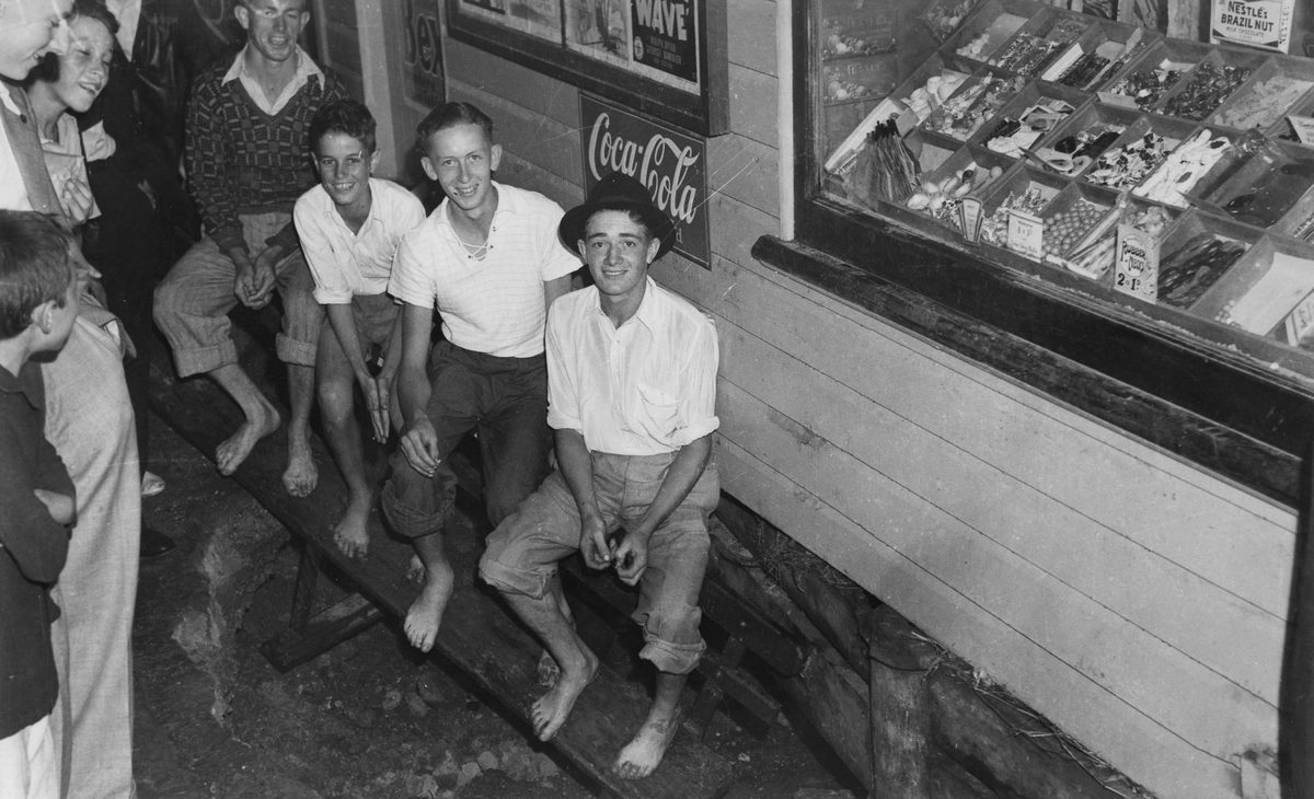 Boys seated outside a shop at Fireways, Wilston, Brisbane, 1940
