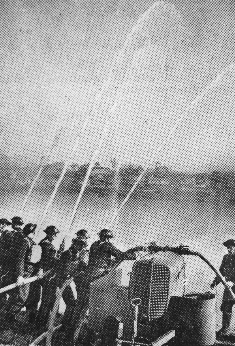 Volunteer firemen throwing up a barrage of water from their hoses during their display at the Domain, Brisbane, 1942