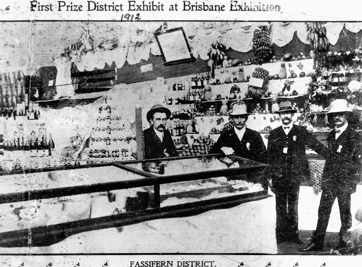 Four gentlemen inspect the Fassifern District Exhibit which won first prize at the Brisbane Exhibition, 1912
