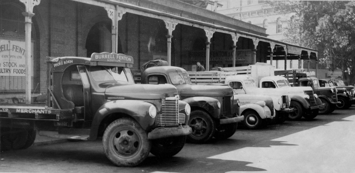 Motor vehicles unloading produce at the markets in Roma Street, Brisbane, 1951