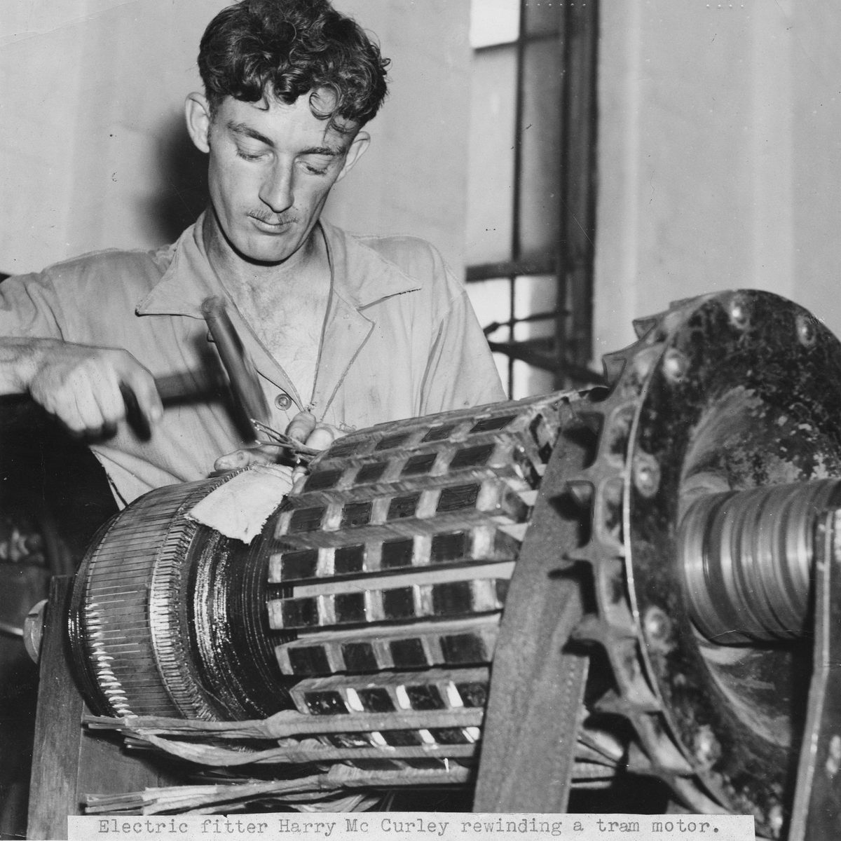 Electric fitter Harry McCurley rewinding a tram motor, Brisbane, 1949