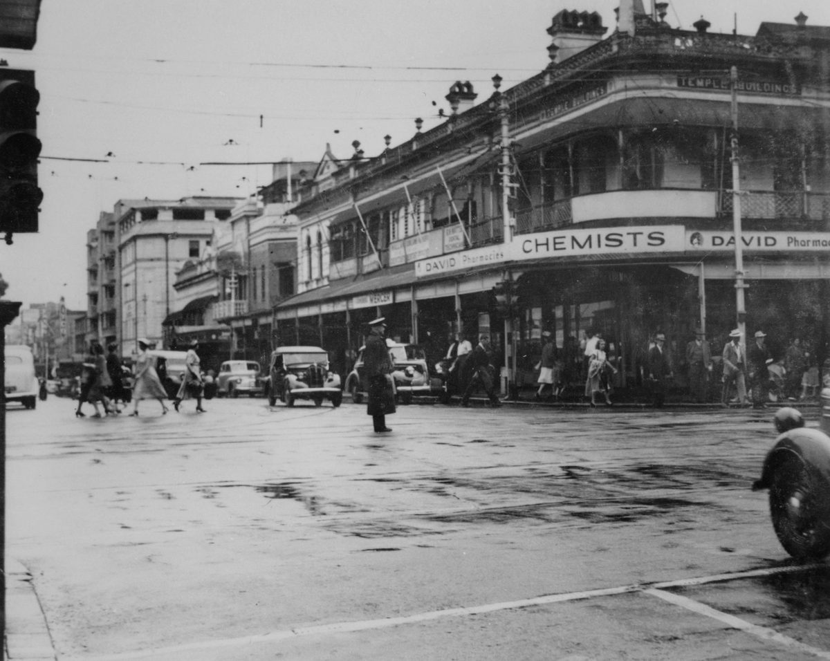 Police officer directing traffic on George Street, Brisbane, 1950