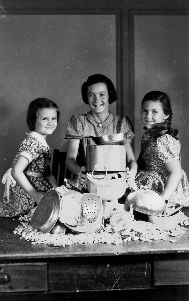 Three girls contributing to the war effort by collecting pots, Brisbane, 1942