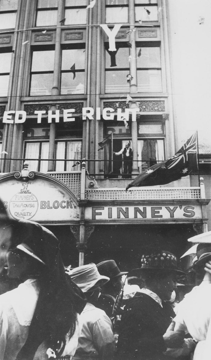 Crowd gathers outside of Finney's to watch the Peace Celebration Day procession, Brisbane, 1918