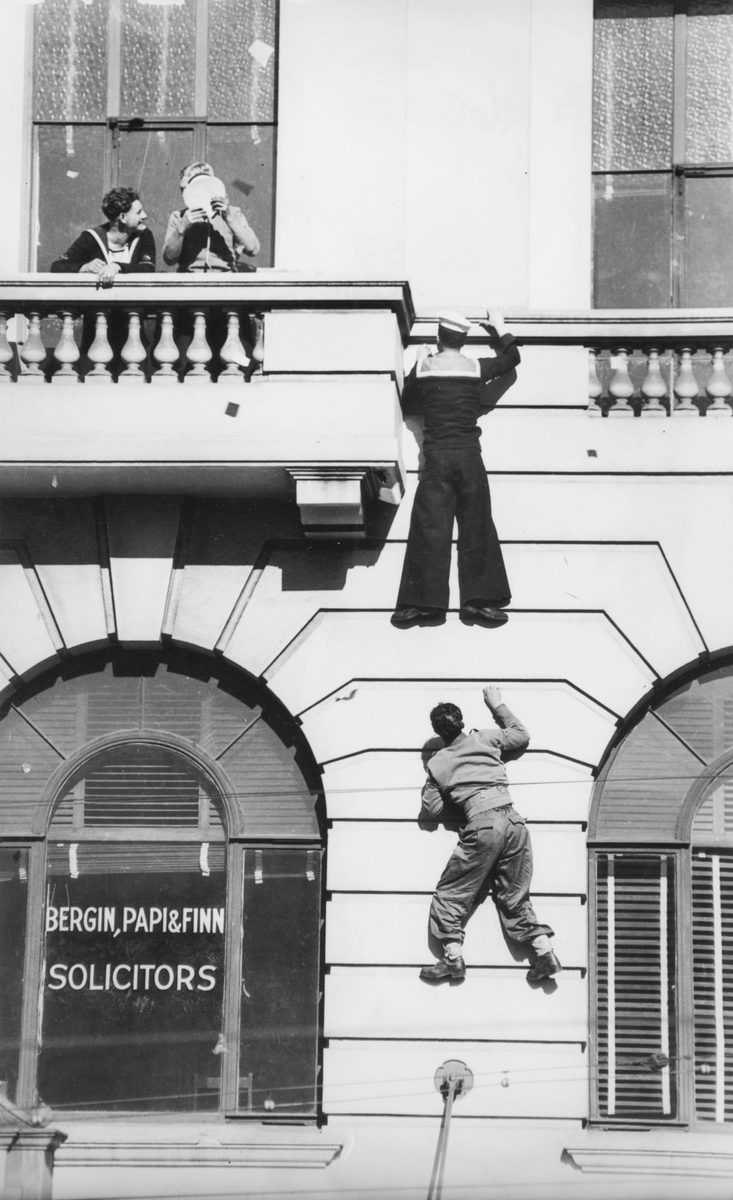 Soldiers scaling a wall on VJ Day in Brisbane, 1945