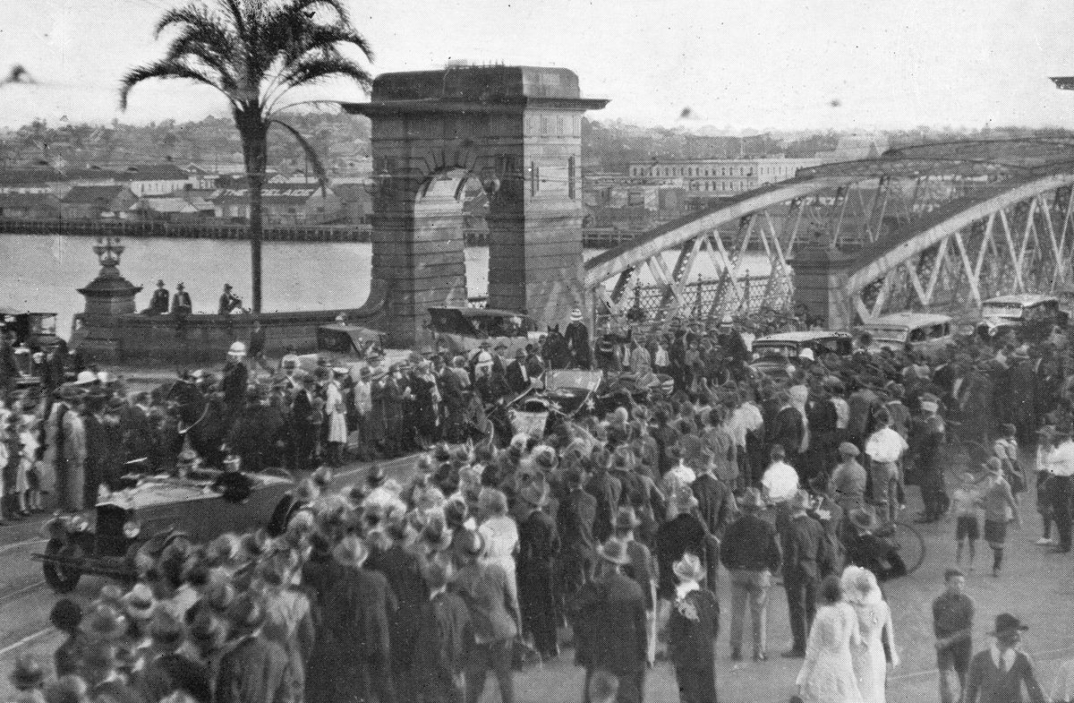 Pilot C. W. A. Scott waves to the crowd from a procession car at Victoria Bridge, Brisbane, 1931