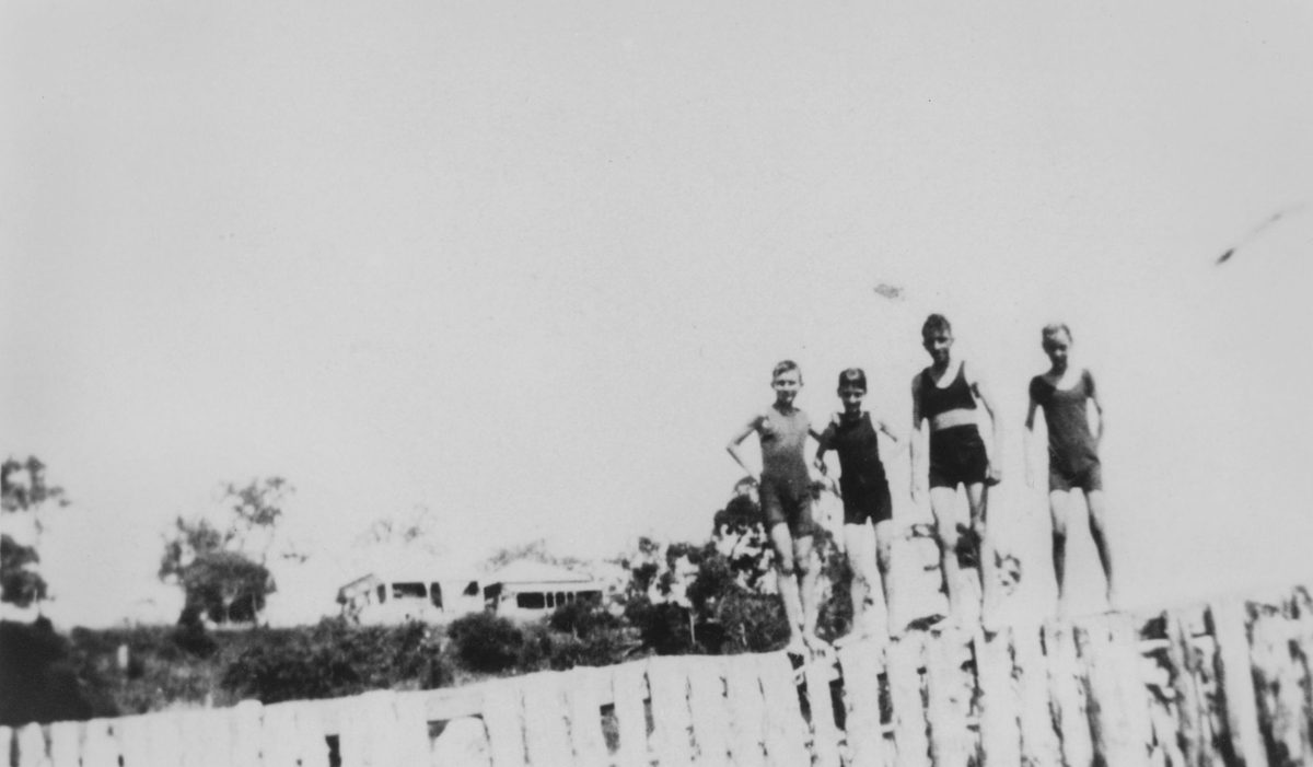 Young boys standing on the wall of the bathing enclosure, Wellington Point, 1924