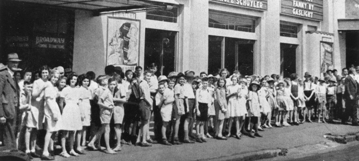 School children lined up on the footpath outside a cinema in Brisbane, 1945